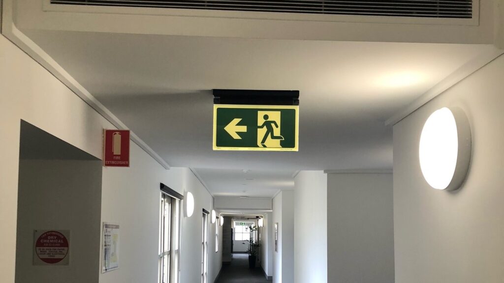 Safety Path Hybrid Exit Sign in corridor of Melbourne Business School